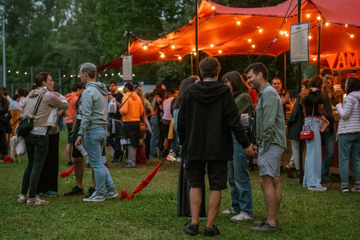 Invités réunis sous des tonnelles événementielles éclairées, le soir